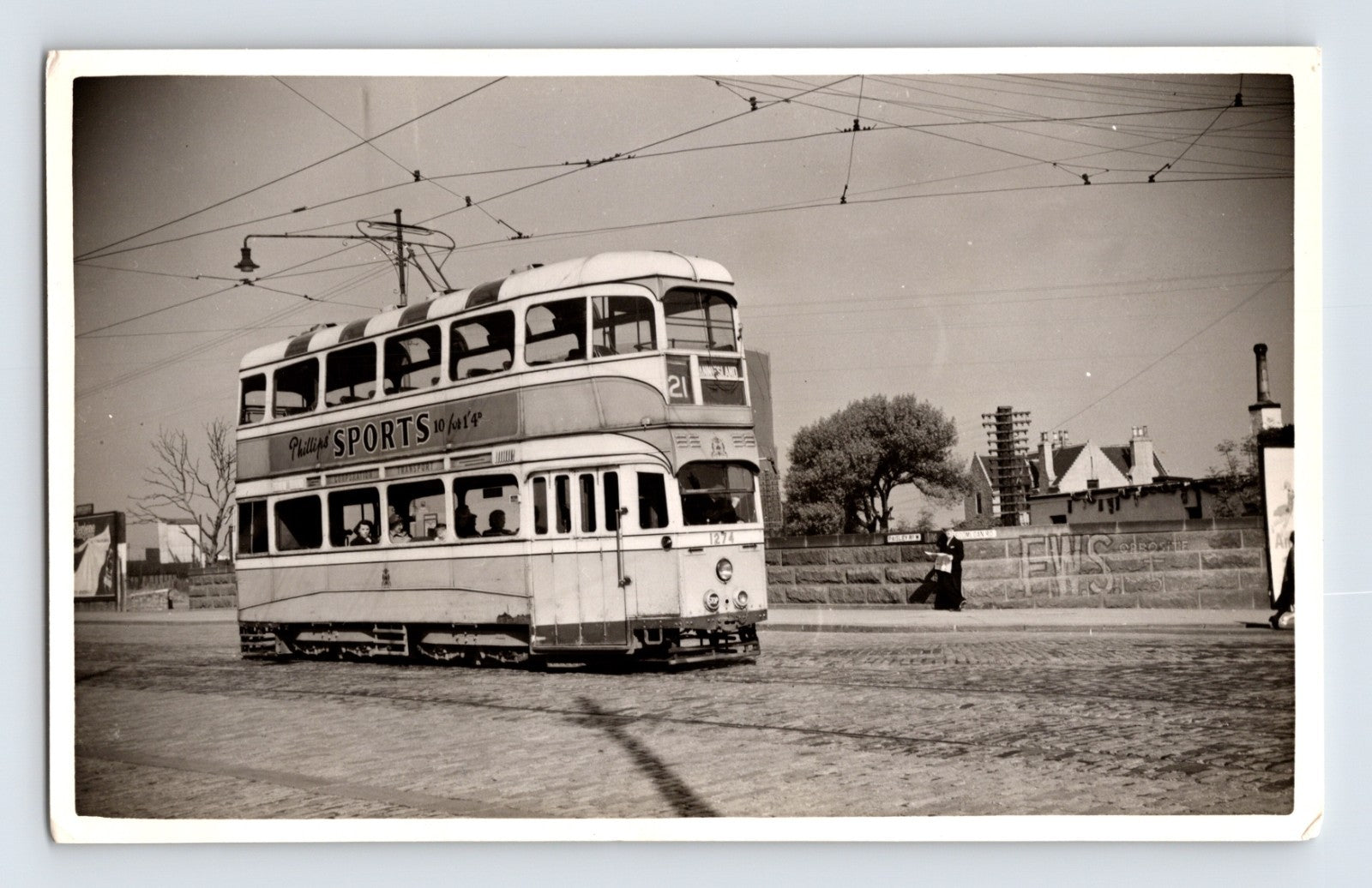 British double deck tram Route 21 West Island Phillips Sports advert cobbled street 1930s