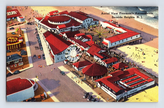 Aerial illustration view of Freeman’s Amusements and boardwalk complex along the beachfront at Seaside Heights, New Jersey, showing rides, pavilions, and adjacent Strand structure, 1940s postcard