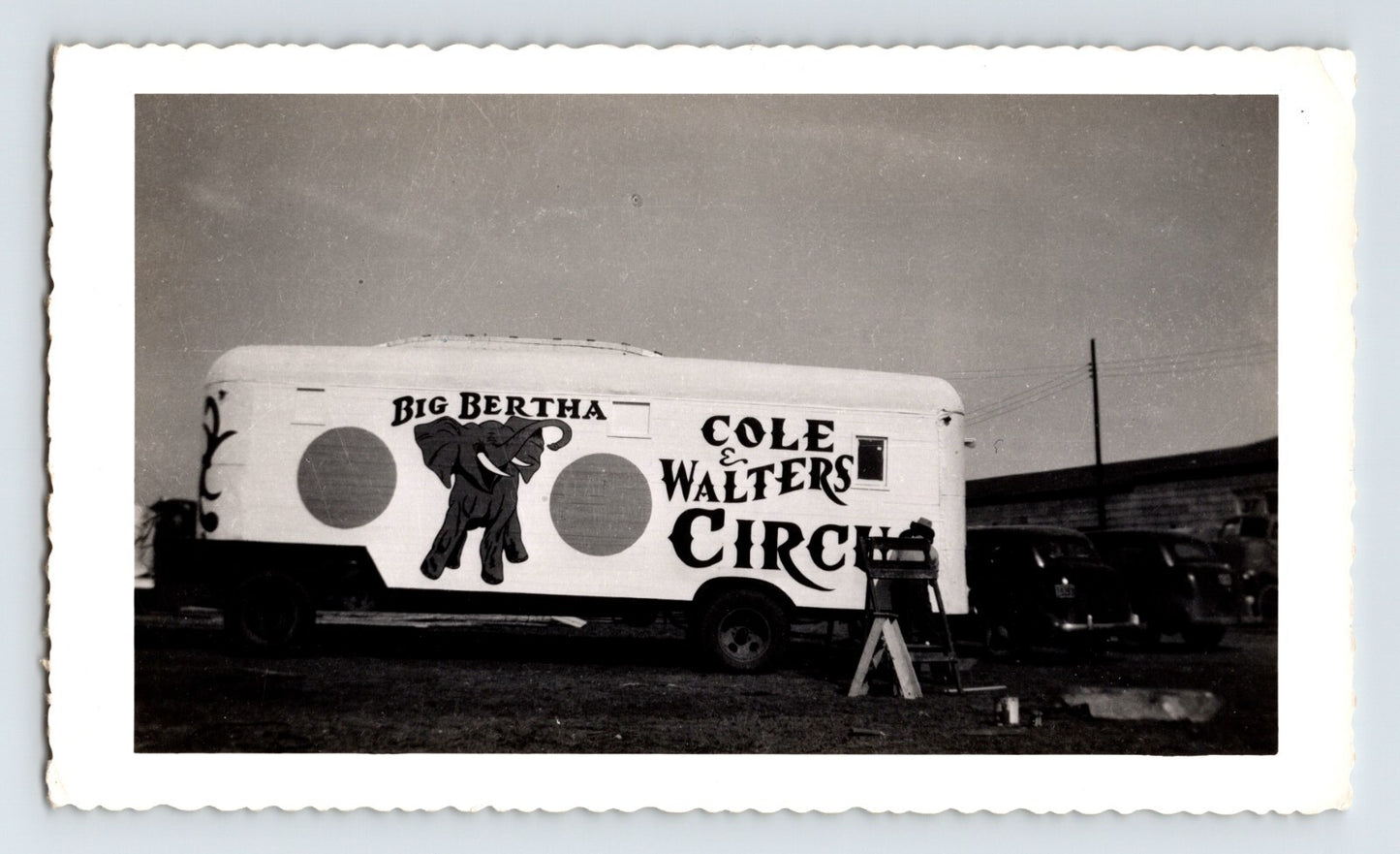 Black and white photograph of Cole Walters Circus elephant trailer marked Big Bertha in Hugo Oklahoma with circus vehicles parked nearby