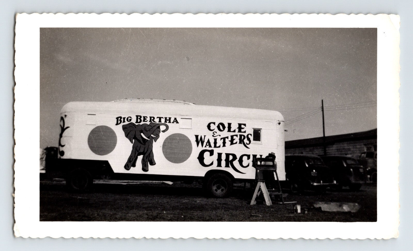 Black and white photograph of Cole Walters Circus elephant trailer marked Big Bertha in Hugo Oklahoma with circus vehicles parked nearby