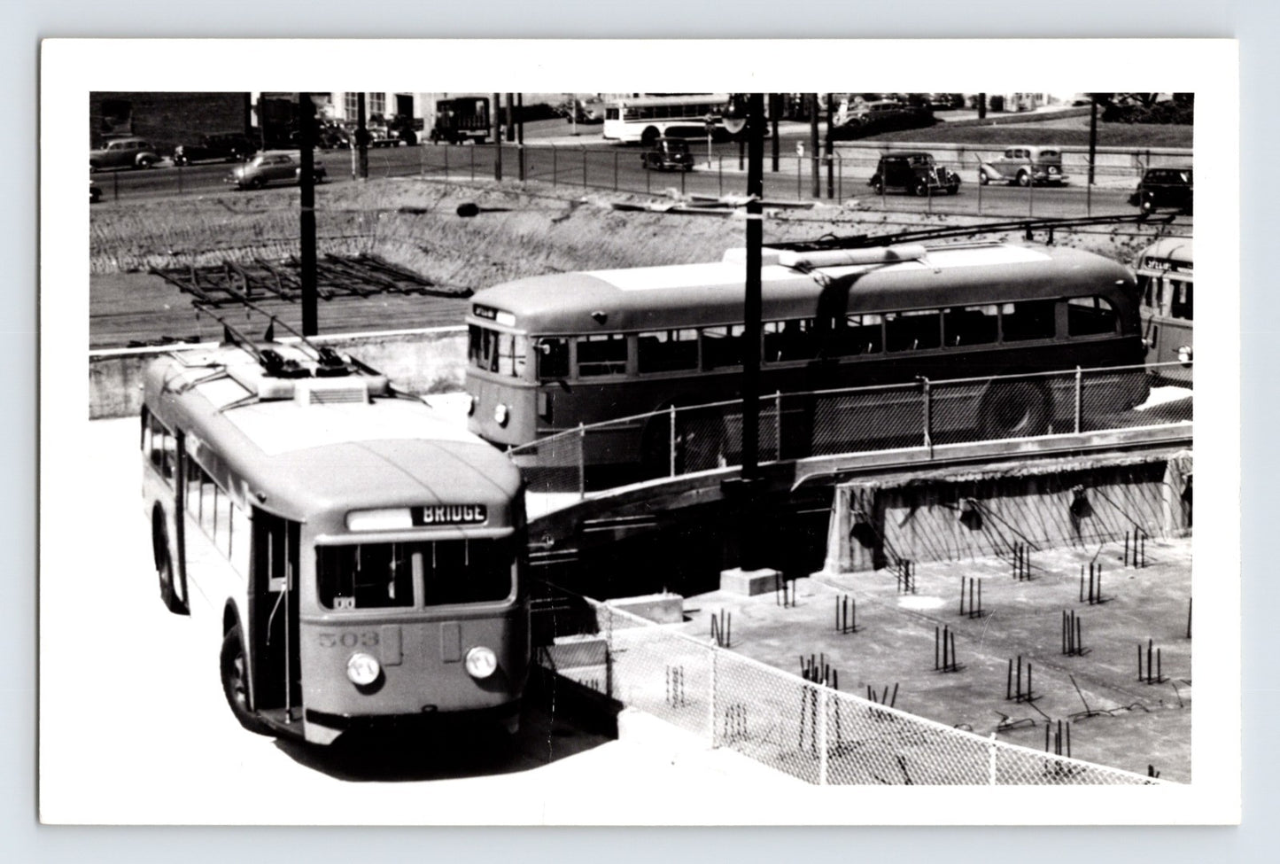 San Francisco Muni St. Louis Car Company trolley coaches loading near bridge approach, June 1941, overhead wires and construction site visible