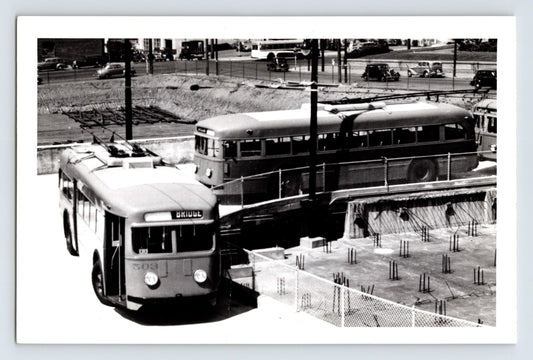 San Francisco Muni St. Louis Car Company trolley coaches loading near bridge approach, June 1941, overhead wires and construction site visible