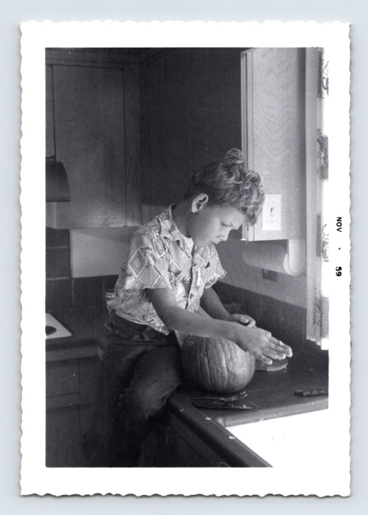 Boy carving pumpkin kitchen countertop mid century Halloween snapshot