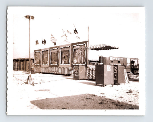 Vintage photo showing Clyde Beatty Circus side show banner entrance with poster panels and flags 1950s
