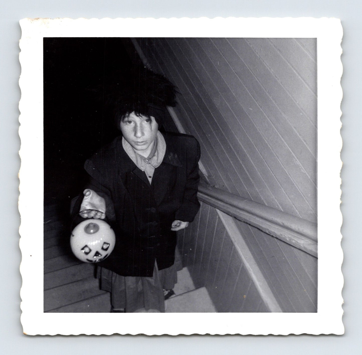 boy holding jack o lantern candy bucket on stairs Halloween 1964 black and white photo