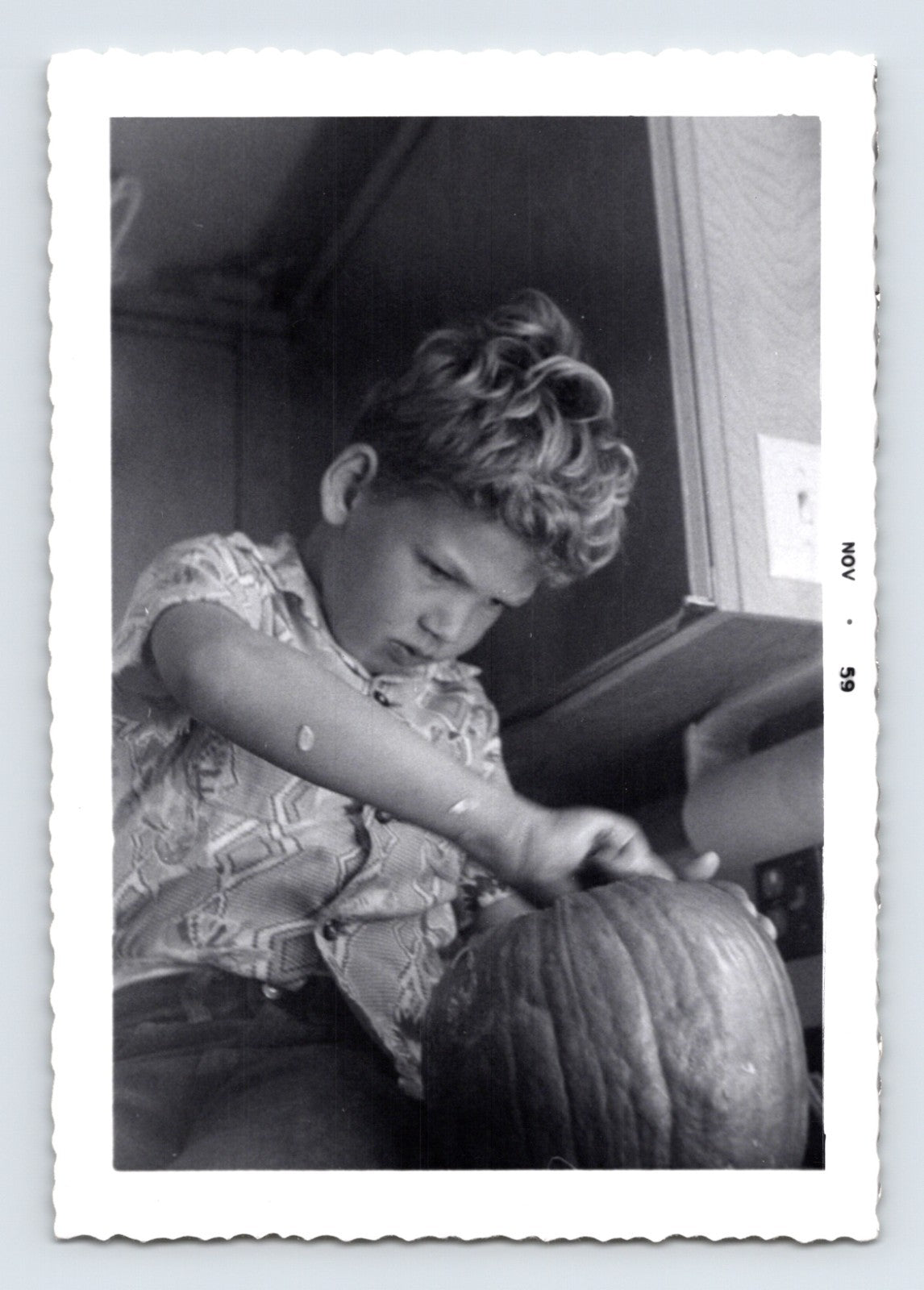 Boy carving pumpkin kitchen counter Halloween preparation mid century snapshot