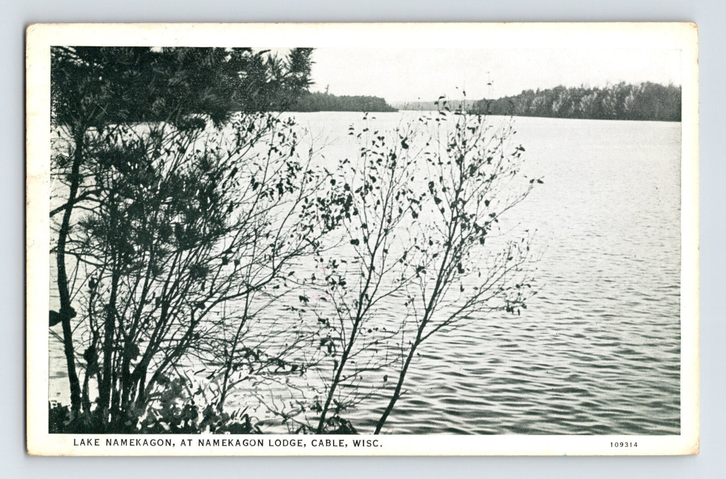 Lake Namekagon at Namekagon Lodge in Cable Wisconsin showing wooded shoreline and calm lake water in black and white