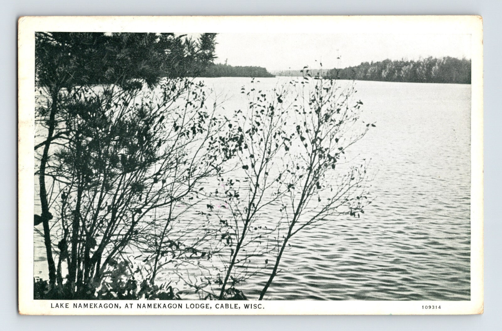 Lake Namekagon at Namekagon Lodge in Cable Wisconsin showing wooded shoreline and calm lake water in black and white