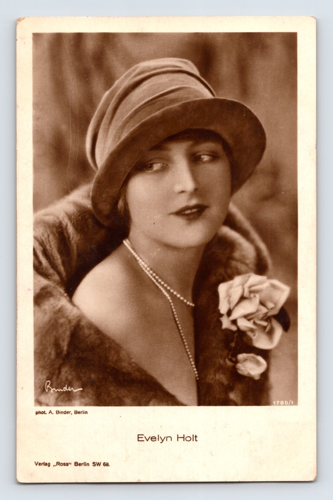 Sepia-tone portrait postcard of silent film actress Evelyn Holt wearing a cloche-style hat, pearl necklace, and fur wrap, published by Ross Verlag in Berlin.