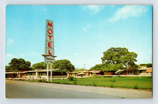 Color chrome postcard of Ridgewood Motel in Austin Texas with tall vertical roadside sign and single story motor court buildings