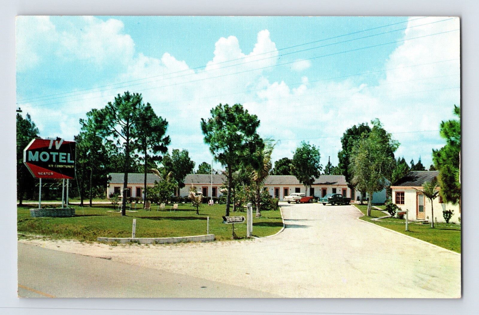 Color chrome postcard view of the TV Motel in Stuart, Florida, showing a landscaped mid-century motor court with curved driveway and roadside signage.