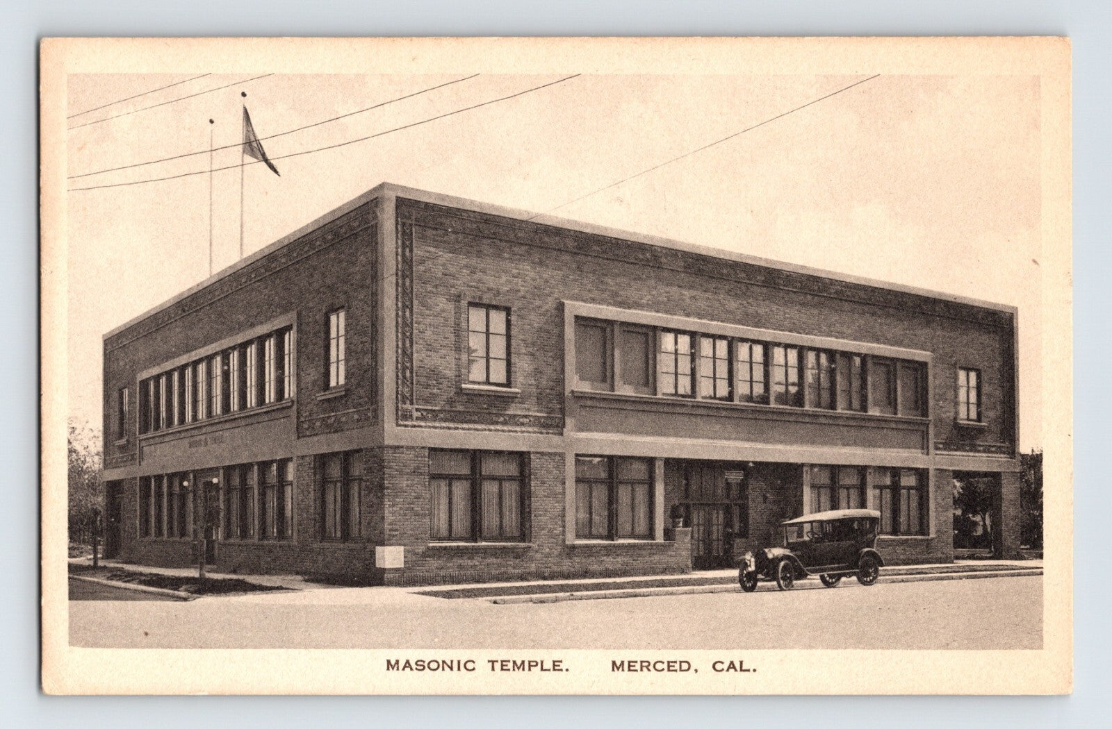 Merced California Masonic Temple brick building with early automobile parked outside, 1920s postcard