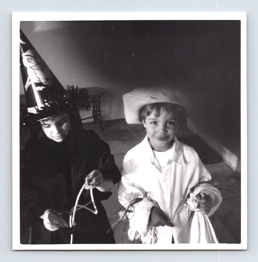 Children Halloween costumes scarecrow and witch holding candy bags 1960s snapshot photo