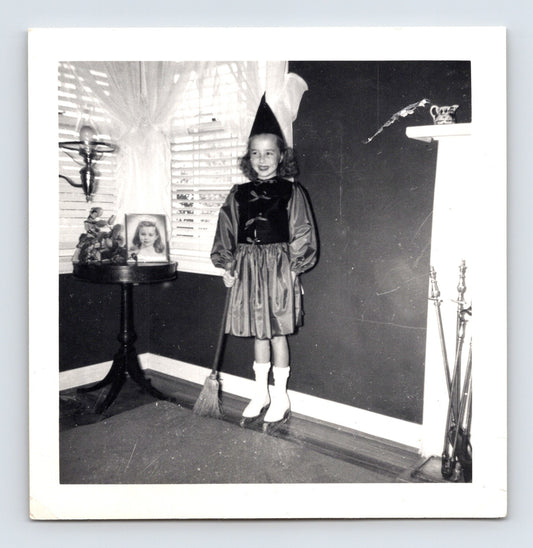 Vintage Halloween witch costume girl broom hat indoor living room 1950s snapshot black white photo