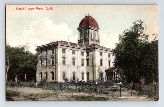 1910s Yreka California courthouse hand colored postcard showing domed civic building with fenced grounds and surrounding trees