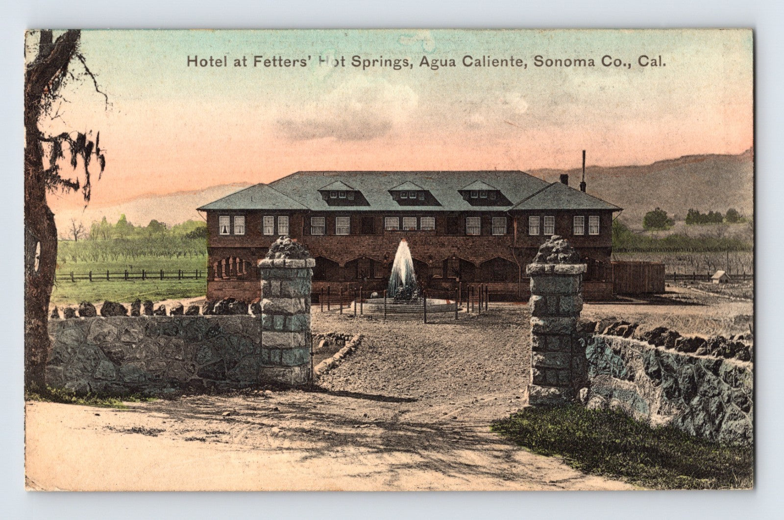 Agua Caliente California Fetters Hot Springs hotel postcard showing stone entrance pillars, central fountain, and resort hotel building in Sonoma County landscape.