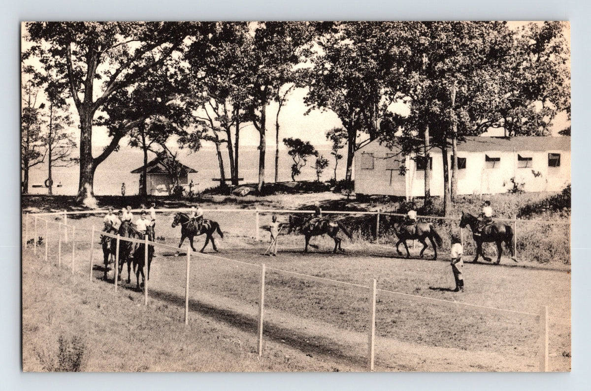 East Hampton New York Camp St Regis horseback riding scene 1950s postcard with riders along fenced path and lakeside camp buildings