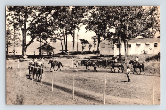 East Hampton New York Camp St Regis horseback riding scene 1950s postcard with riders along fenced path and lakeside camp buildings