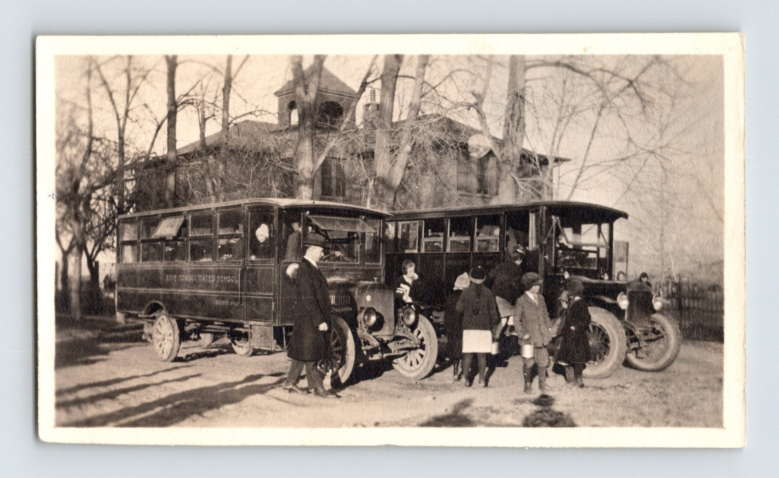 Kansas Erie Consolidated School 1930s photo showing early school bus with children and teachers gathered outside rural building
