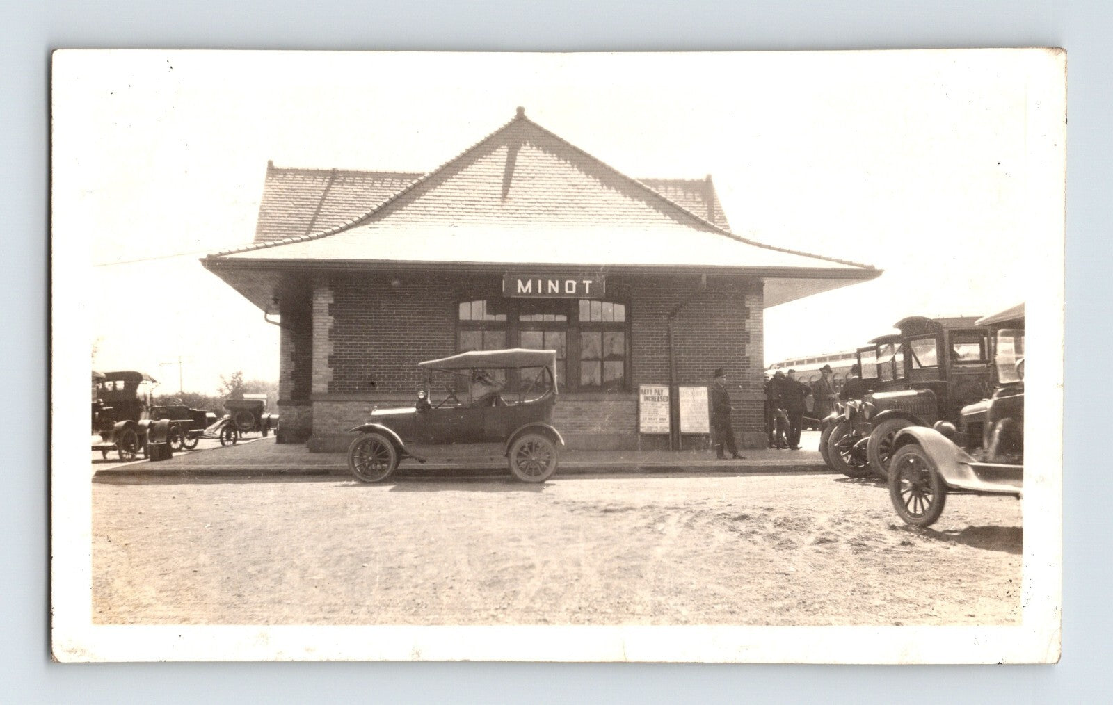 Minot North Dakota railroad depot 1920s photograph with early automobiles parked outside station building