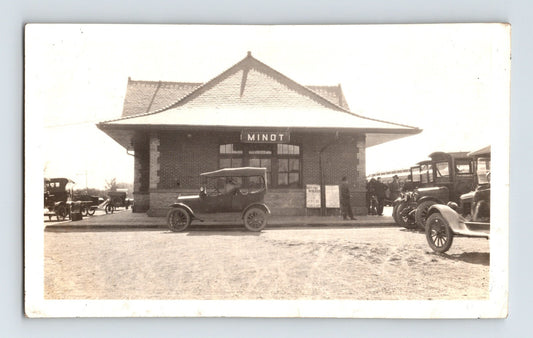 Minot North Dakota railroad depot 1920s photograph with early automobiles parked outside station building