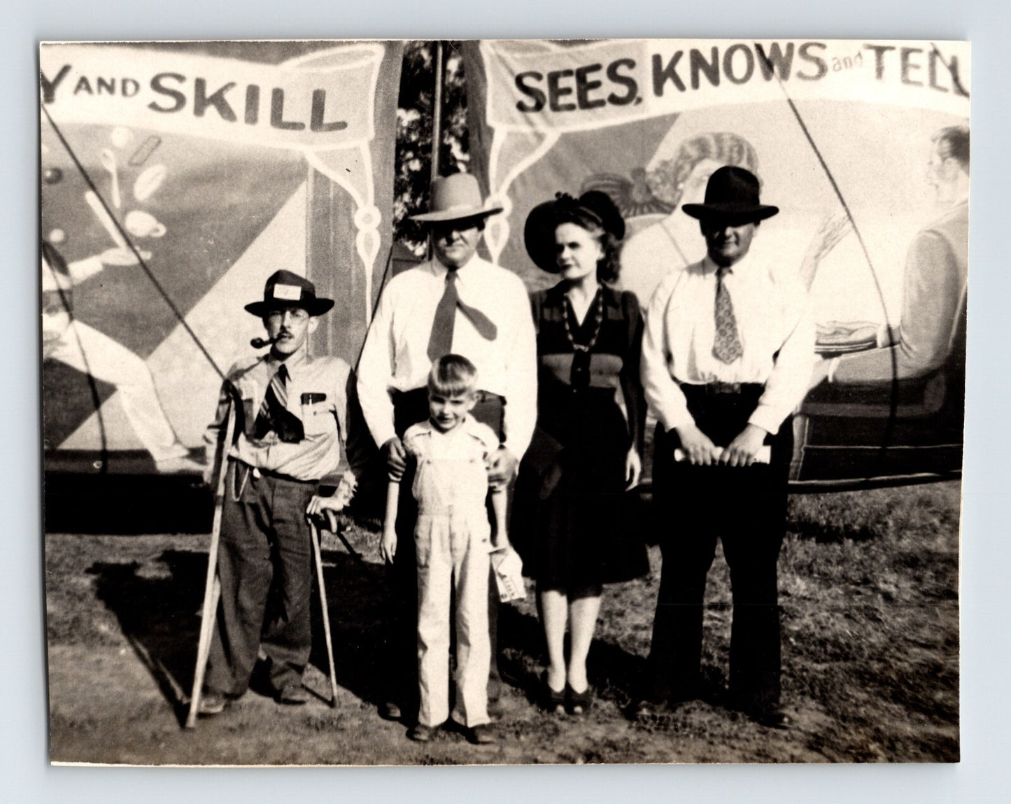 Cole Brothers Circus sideshow banner backdrop with group of adults and child posed in front, Salina, Kansas, 1946 photograph.