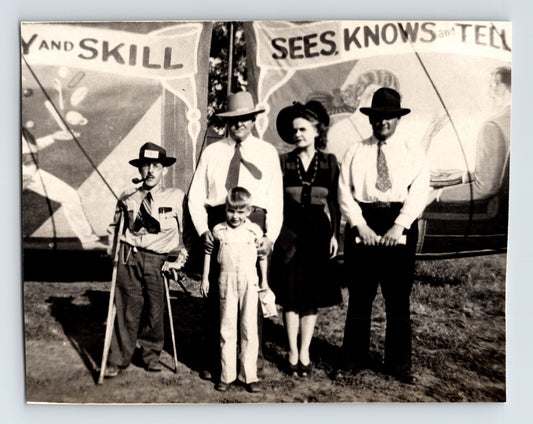 Cole Brothers Circus sideshow banner backdrop with group of adults and child posed in front, Salina, Kansas, 1946 photograph.