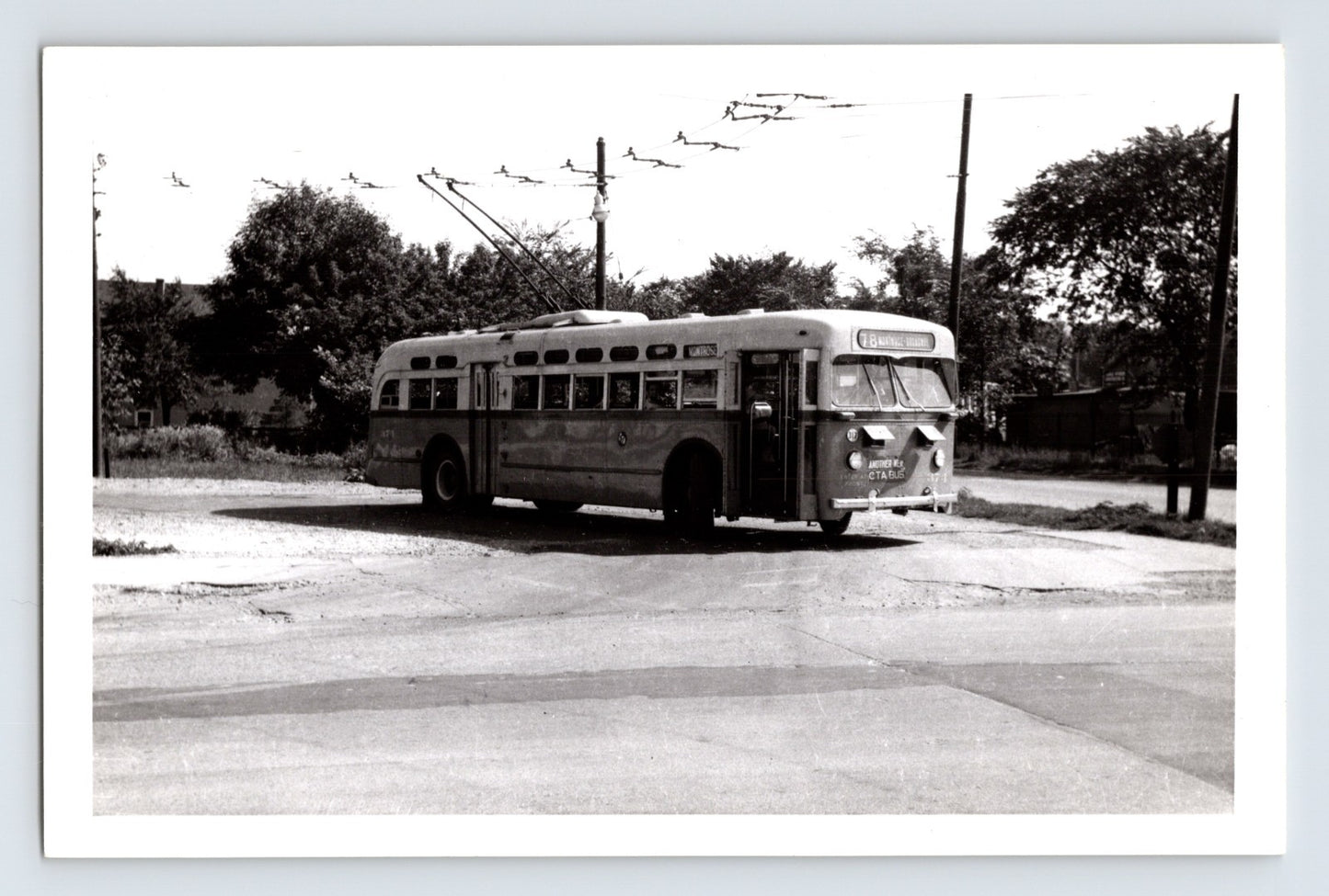 Chicago Surface Lines trolley bus 374 on Montrose route turning at intersection with overhead wires visible, black and white transit photo circa 1950s
