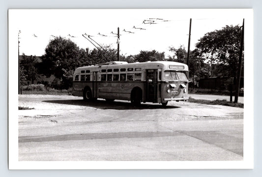 Chicago Surface Lines trolley bus 374 on Montrose route turning at intersection with overhead wires visible, black and white transit photo circa 1950s