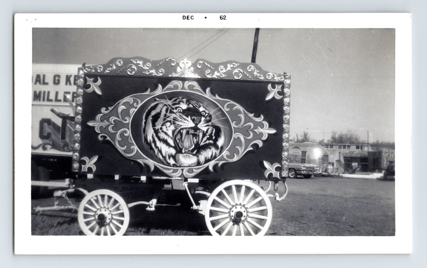 Black and white photograph of Kelly Miller Circus wagon with painted tiger tableau and decorative scrollwork panels, dated December 1962