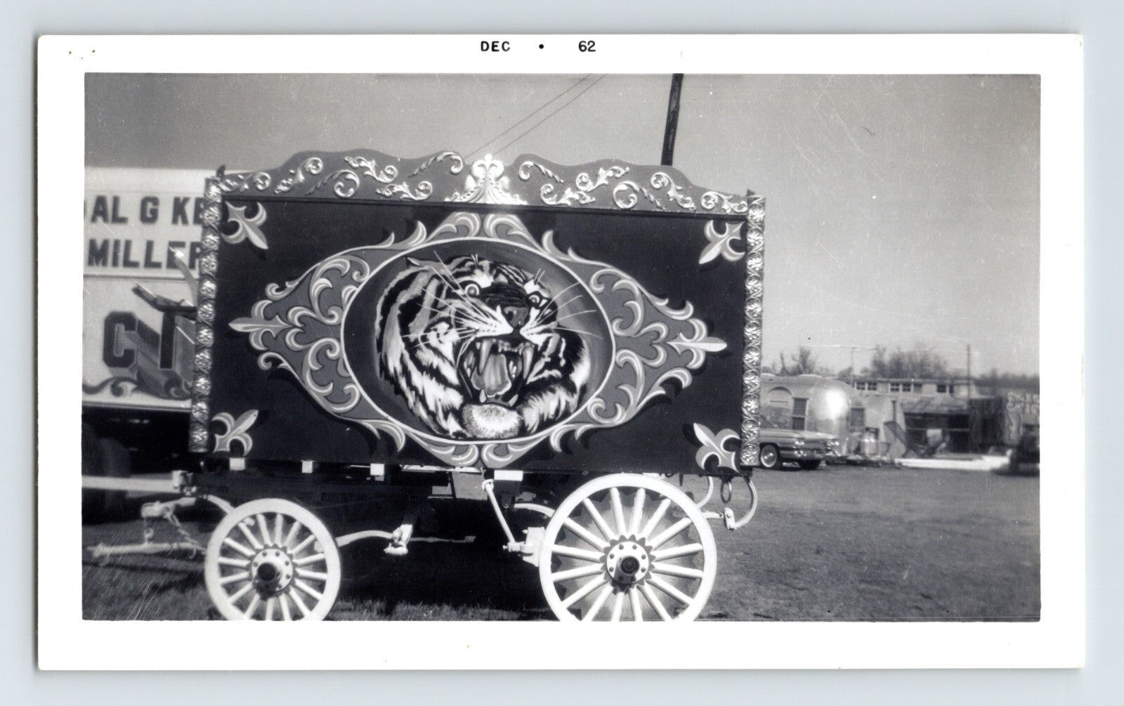 Black and white photograph of Kelly Miller Circus wagon with painted tiger tableau and decorative scrollwork panels, dated December 1962