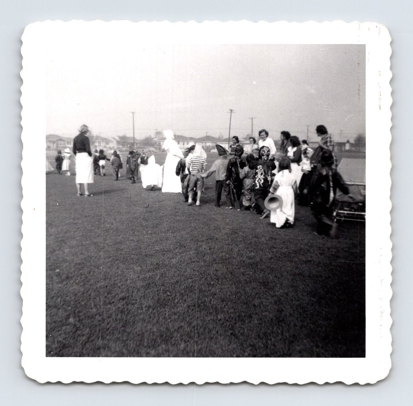 Children Halloween costume parade outdoor field line of kids masks 1953 snapshot