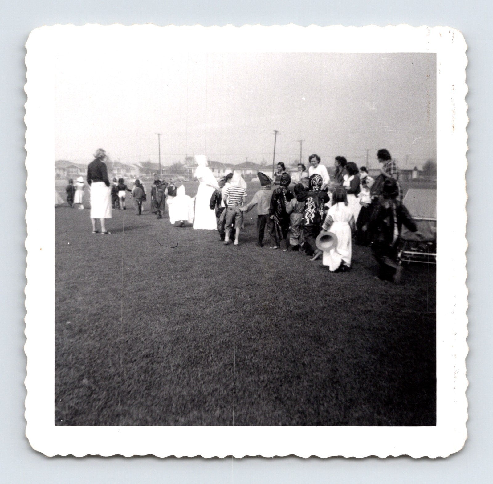 Children Halloween costume parade outdoor field line of kids masks 1953 snapshot