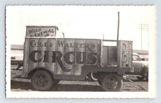 1952 photograph showing a Cole & Walters Circus wild animal trailer and props vehicle parked near circus grounds in Hugo, Oklahoma.
