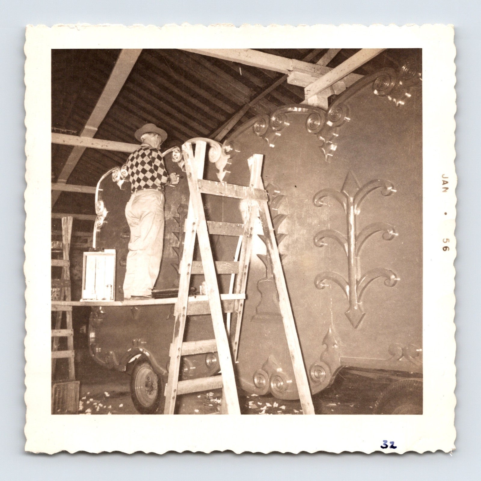 King Bros Circus 1956 photo worker on ladder repairing illuminated circus wagon panel inside winter quarters barn