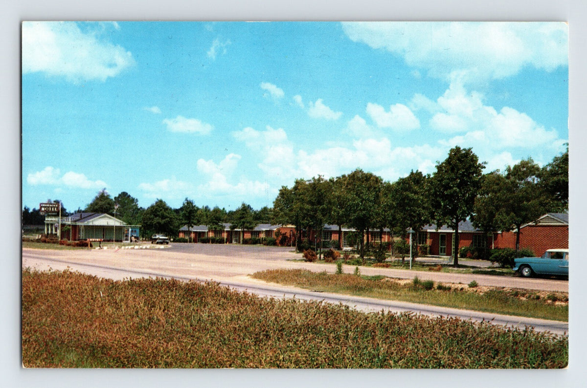 1960s chrome postcard showing the Shamrock Motel in Montgomery, Alabama, with low-rise brick motel units, roadside frontage, and parked automobiles along a divided highway.