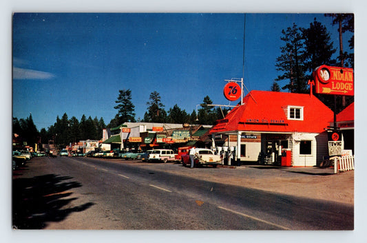 Main Street in Big Bear Lake California showing Indian Lodge motel and Union Oil 76 gas station with red roof and vintage automobiles