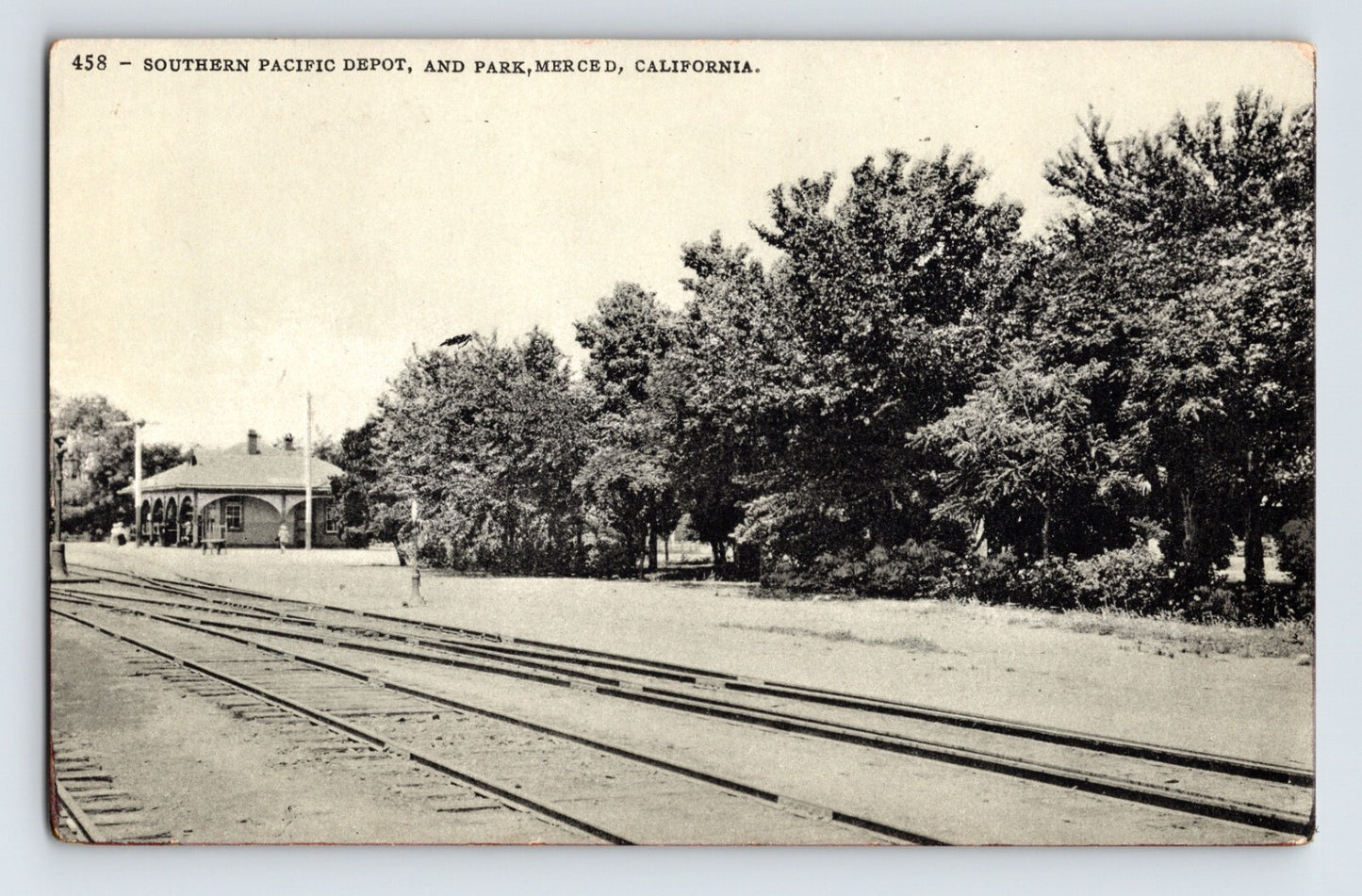 Merced California Southern Pacific Railroad depot and park with tracks in foreground 1910s postcard