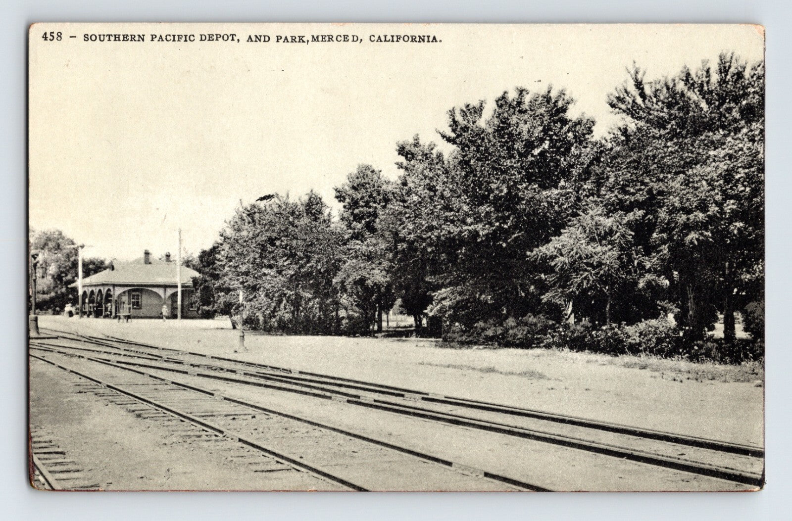 Merced California Southern Pacific Railroad depot and park with tracks in foreground 1910s postcard