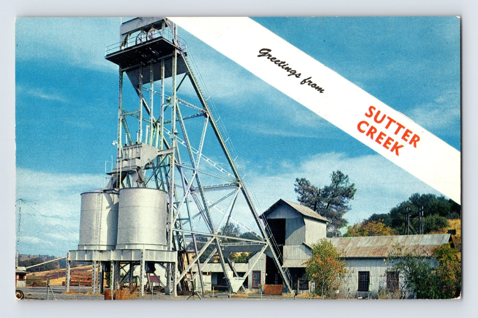 Sutter Creek California Mother Lode mining postcard featuring the Eureka Mine headframe, ore silos, and historic gold rush industrial structures.