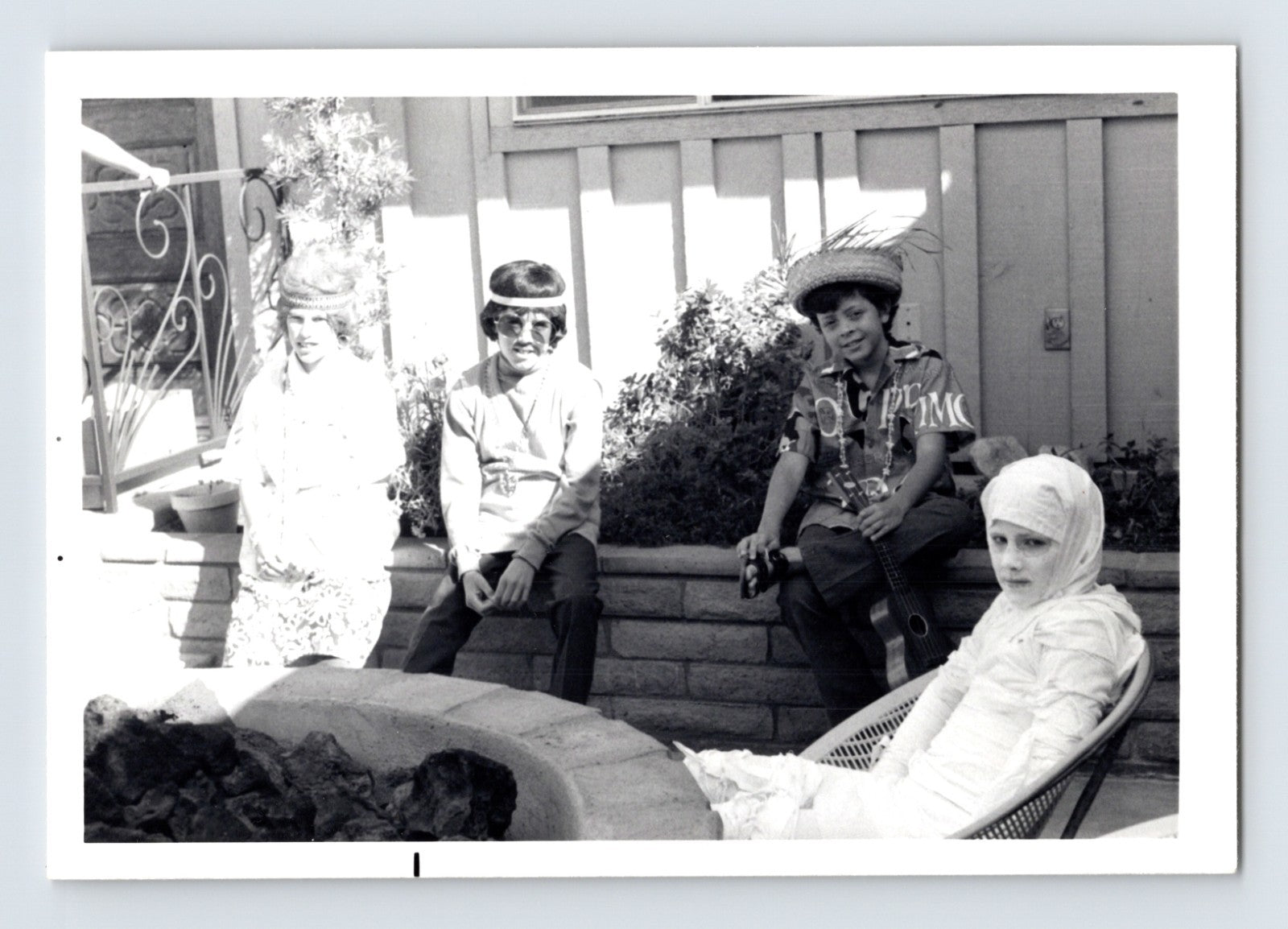 Children Halloween costumes seated patio fire pit mummy guitar hats mid century snapshot