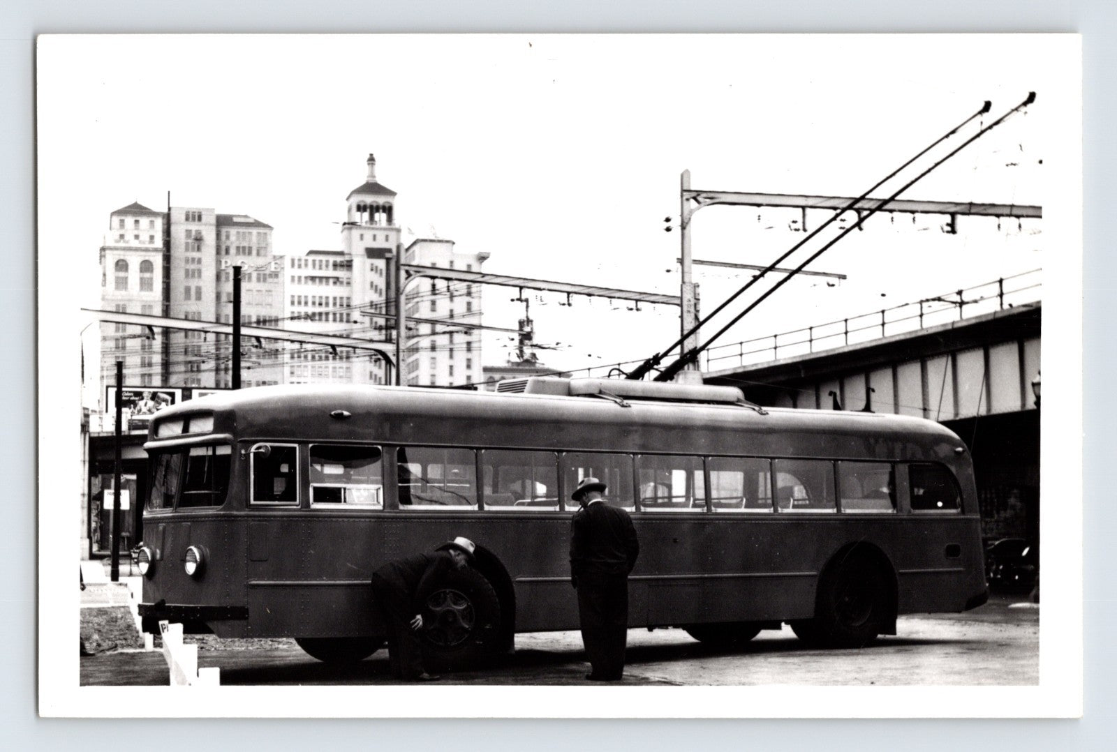 San Francisco Muni St Louis Car Company trolley coach June 1941 under elevated tracks with downtown buildings in background