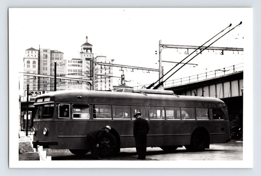 San Francisco Muni St Louis Car Company trolley coach June 1941 under elevated tracks with downtown buildings in background