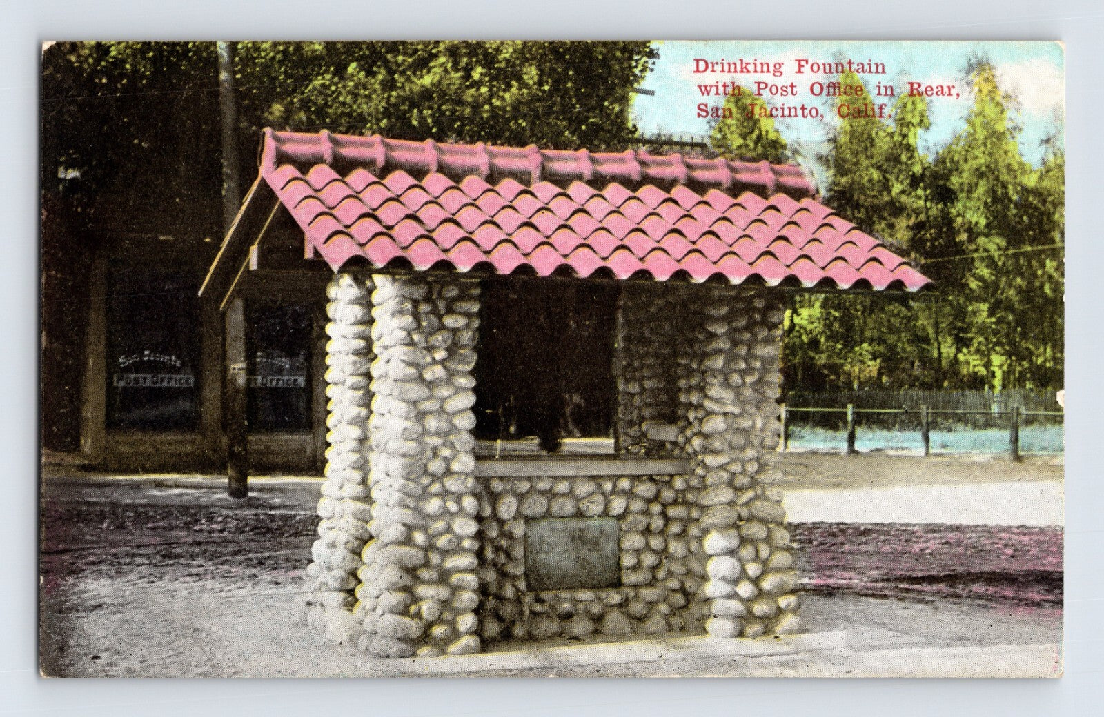 San Jacinto California post office drinking fountain built of rounded river stones with red tile roof in early twentieth century streetscape
