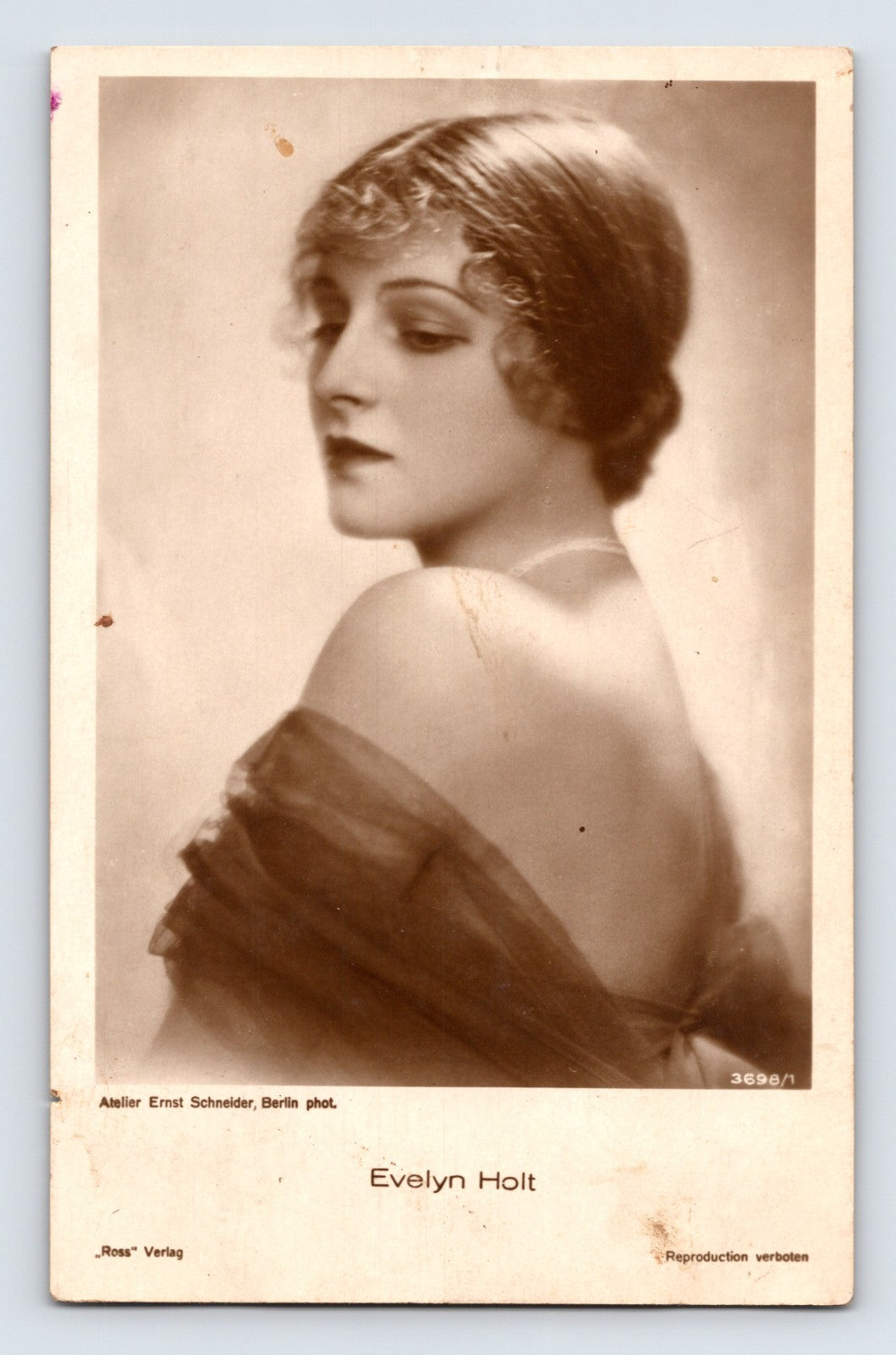 Sepia-tone portrait postcard of silent film actress Evelyn Holt posed in profile with an elegant sheer wrap and softly lit Art Deco-era studio styling.