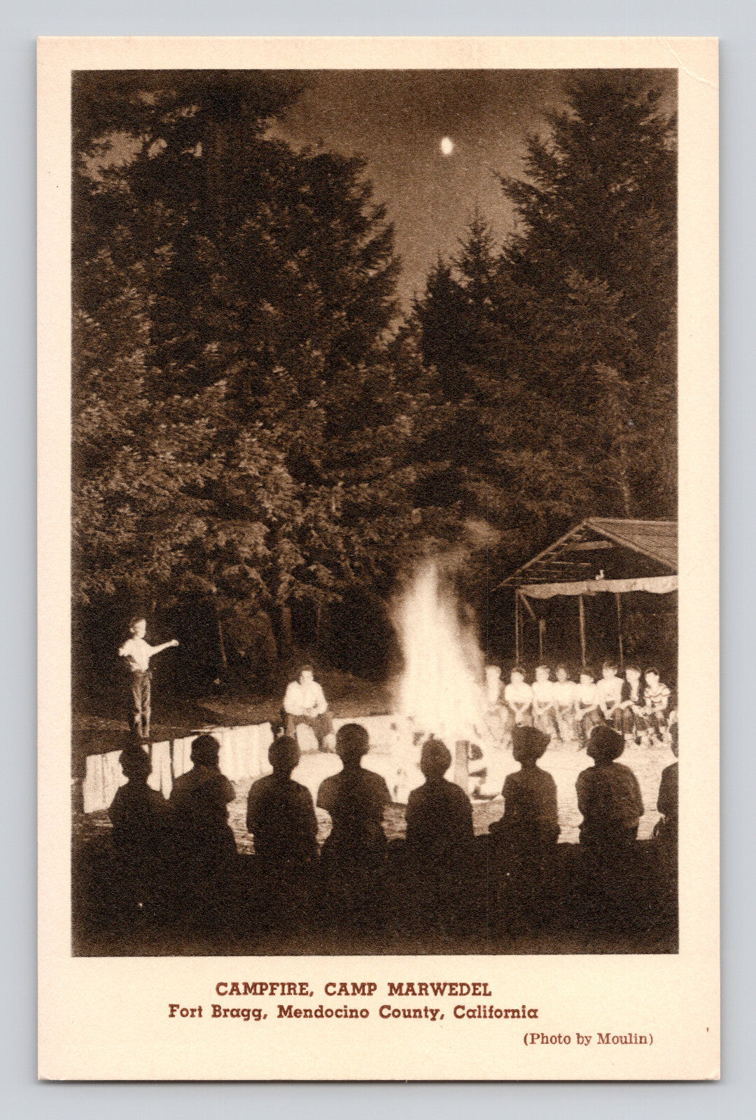 Fort Bragg California Camp Marwedel campfire 1940s postcard with group gathered around fire at night in forest setting