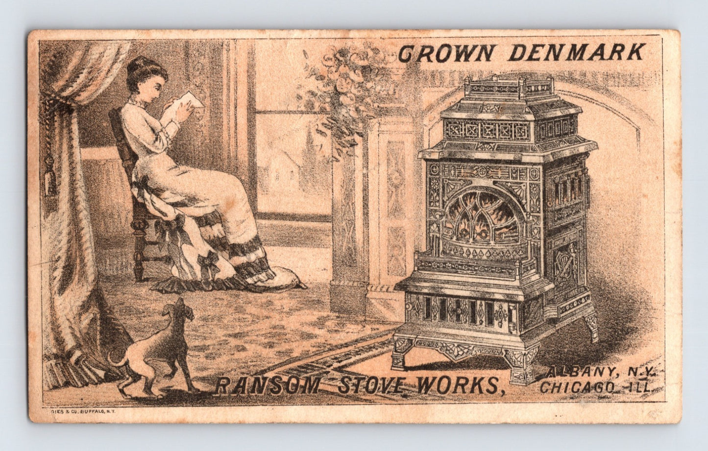 Ransom Stove Works Crown Denmark stove trade card featuring ornate parlor stove interior scene with woman reading and dog, Rochester New York advertising reverse.